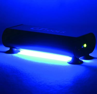 GT Tools UV curing light for windshield repair emitting a bright blue glow on a flat surface.