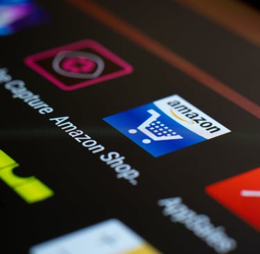 Ejecutivos de Amazon frente a pantallas con gráficos de inteligencia artificial, representando los recortes de 14 000 empleos