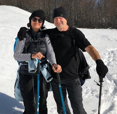 a man and woman standing in the snow