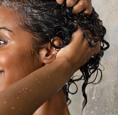 a woman is holding her hair in front of her head