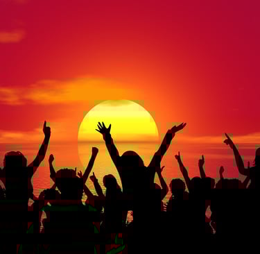 people are partying silhouetted by the setting sun in the background