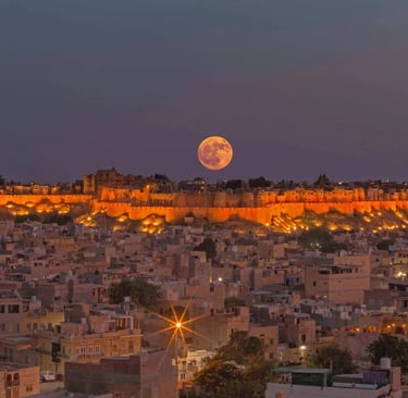a full moon rising over a city with a full moon in the sky