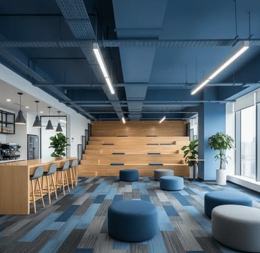 Area de descompressao de empresa com carpete azul e cinza teto azul móveis amadeirados e puffs azuis com bancada e banquetas