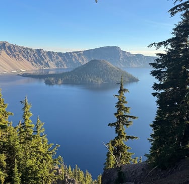 A vibrant aerial shot of Crater Lake's sapphire waters encircled by snow-dusted cliffs, captu
