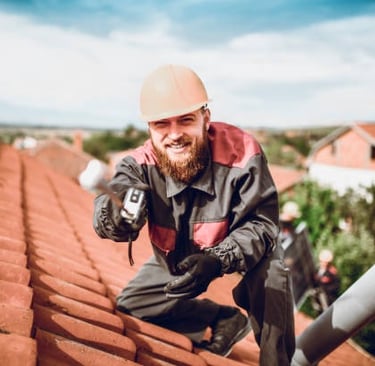 roofing worker smiling for the camera on an orange roof