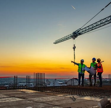 roofing workers pointing into the distant sunset on a commercial roof