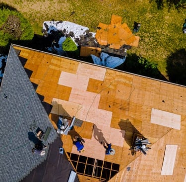 sky view of construction workers installing roof tiles