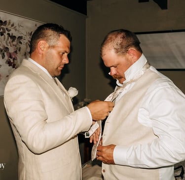 Groom getting ready with groomsman adjusting tie Avalon Castle Melbourne wedding morning