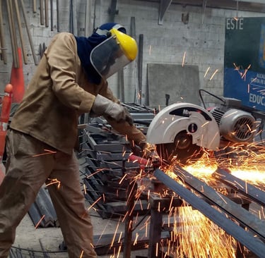 a man in a welding helmet grinding a piece of metal