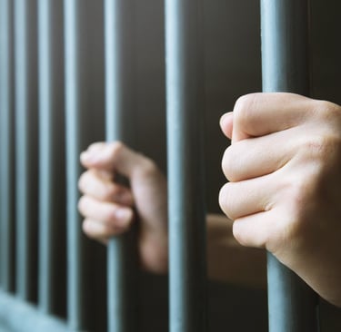 hands on jail cell bars