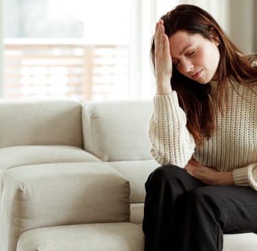 woman with hand on forehand experiencing migraine or pain