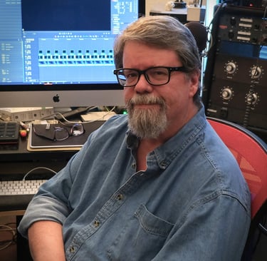 A photo a Jay Walsh, video editor, sitting at his desk.