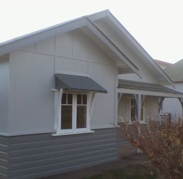 Exterior house repaint detail showing painted weatherboard finish