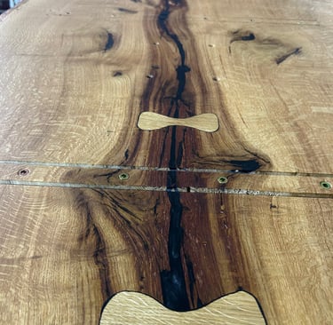 Butterfly Inlays aus Eiche stabilisieren natürliche Trocknungsrisse in einer massiven Eichenbohle.