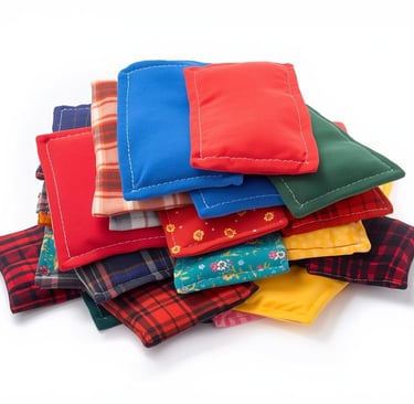 “Stack of handmade fleece and flannel hand warmers in colorful solids, prints, and plaids.