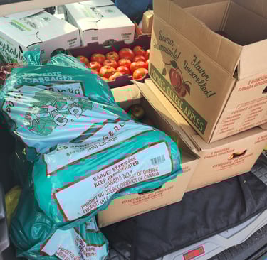 Boxes of produce and one of potatoes.