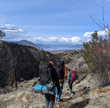 Group of people walking towards the horizon with large packs on