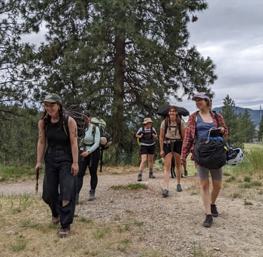 Group of people with climbing gear walking in a treed area