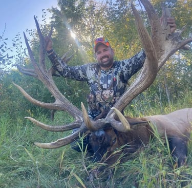 happy hunter with his giant bull elk
