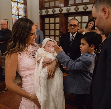 a man and woman holding a baby in a church