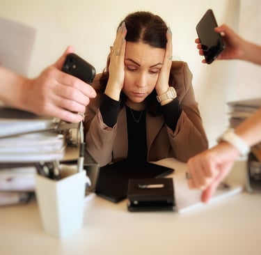 a woman sitting at a desk with her hands on her head, four hands show her watches,she seems stressed