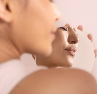 skin care. a woman is looking at her face in the mirror  - click shop button bottom middle of image