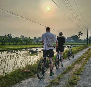 a group of people riding bikes down a village path