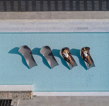 a couple of people sitting in a pool in mykonos