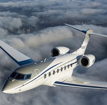 a white jet airplane flying over a cloud filled sky