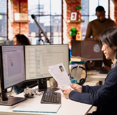 Tampilan sistem HRIS di layar komputer di kantor modern, menggambarkan digitalisasi dan pengembangan sistem sumber daya manus