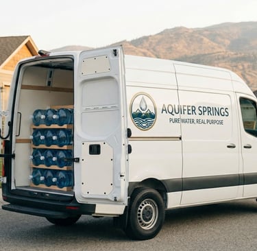 Aquifer Springs delivery van with fresh spring water jugs for home delivery in Kelowna.