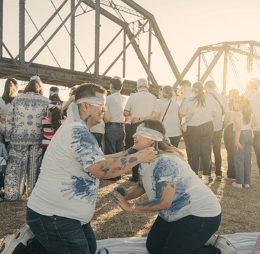 two people playing outdoor paint game blindfolded