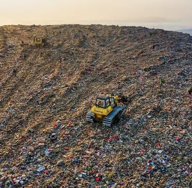 Aerial view of bulldozers managing waste at a large landfill site for environmental disposal.