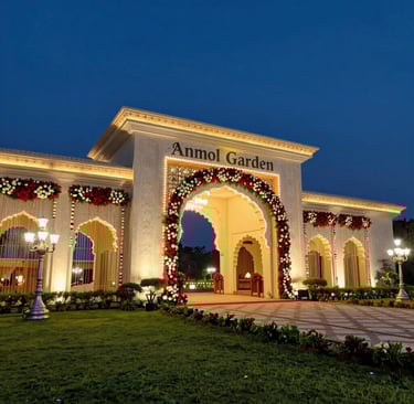 A romantic outdoor wedding setup with golden chairs, red floral aisle runners, and a sunset backdrop.