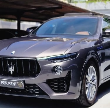 Luxury grey Maserati Levante SUV available for rent parked in a showroom lot.
