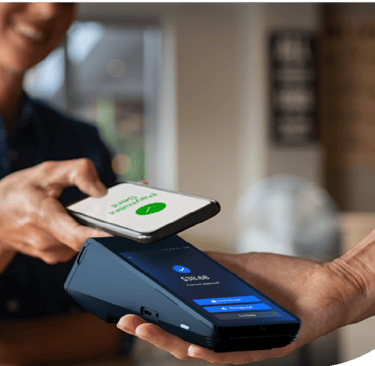 Customer making a contactless mobile payment using a smartphone at a retail POS terminal.
