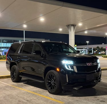 Night view of Miami skyline with luxury cars lined up on a private terrace