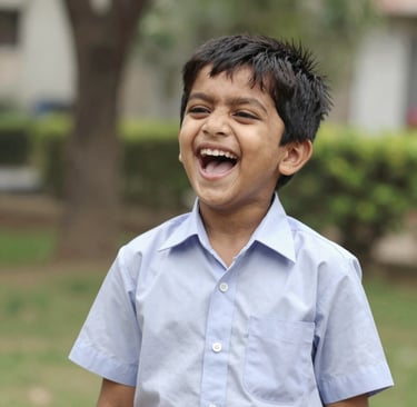 Close-up of a child proudly wearing a full Wonder Wings uniform, including the sports upper and lower, smiling outdoors.
