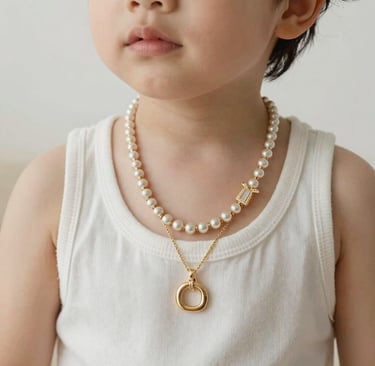 Delicate gold bangles stacked gracefully on a white marble surface with soft natural light.