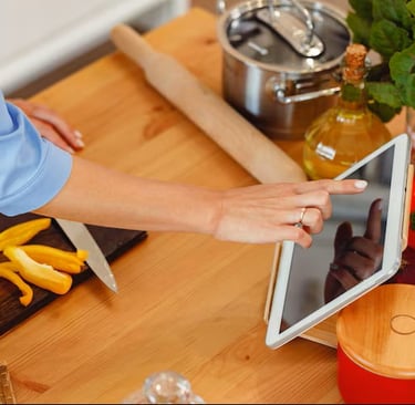 Estudiante aprendiendo vocabulario mientras cocina en cursos dinámicos de idiomas.