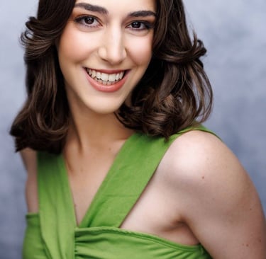 Smiling woman with shoulder-length brown hair wearing a bright green sleeveless top. 