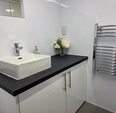 Vanity unit and towel rail inside a fully equipped temporary bathroom pod for renovation use.