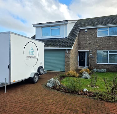 Temporary bathroom pod installed on a residential driveway during a home renovation.