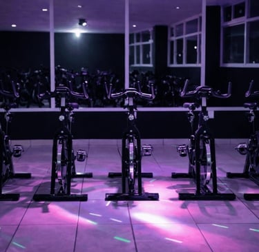 Fila de bicicletas estáticas en un moderno estudio de ciclismo int con iluminación ambiental mora