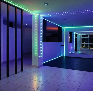 Estudio moderno con iluminación LED azul y verde, espejos grandes y piso de goma negra.