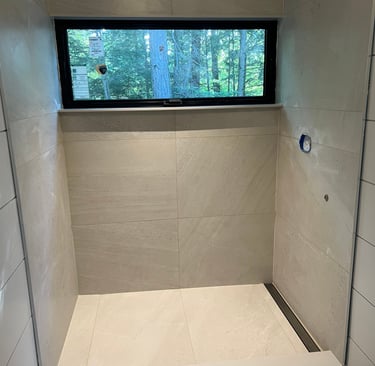 Modern walk-in shower featuring large format beige porcelain tiles.