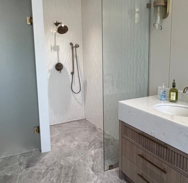Modern bathroom featuring a curbless walk-in glass shower with large format porcelain tiles 