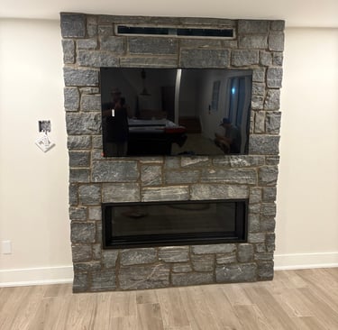 Muskoka granite fireplace wall with mounted TV and linear gas insert.