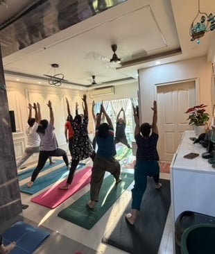 Students in Warrior Pose variation during class