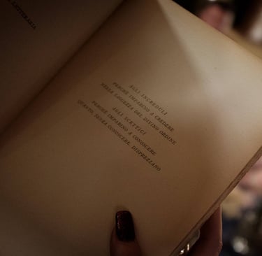 Libro aperto su pagina con scritto: "Agli increduli, perchè imparino a credere"